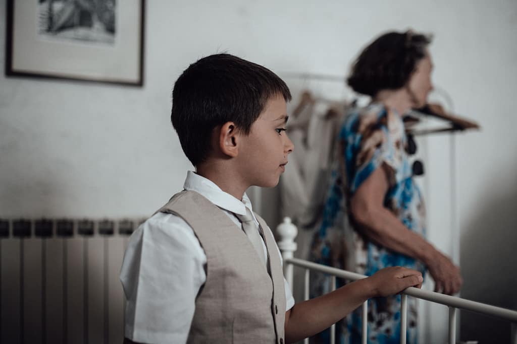 Momenti di Famiglia a Magliano Sabina: I Fratelli che Giocano Insieme Fratellino che gioca sul letto, osservato con affetto dal fratello maggiore, in un momento di intimità familiare a Magliano Sabina (Rieti).