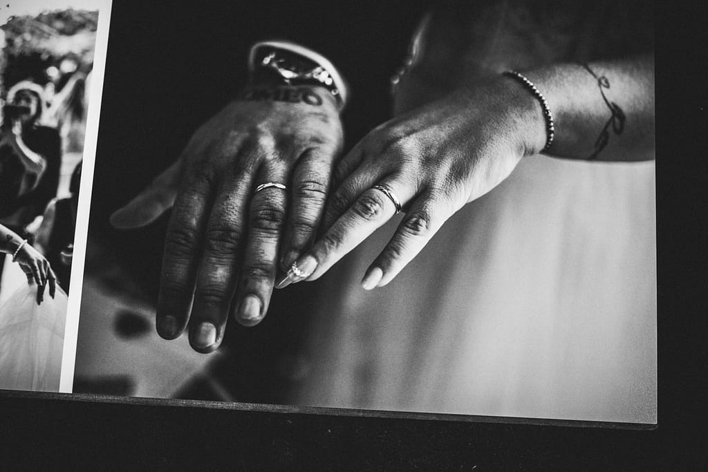 Le mani e le fedi degli sposi sull’album