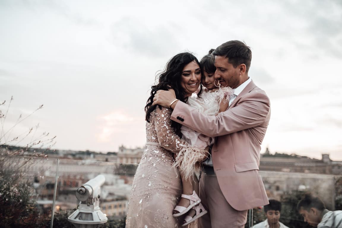 L'abbraccio genitori figlia battesimo a Terrazza Les Étoiles a Roma