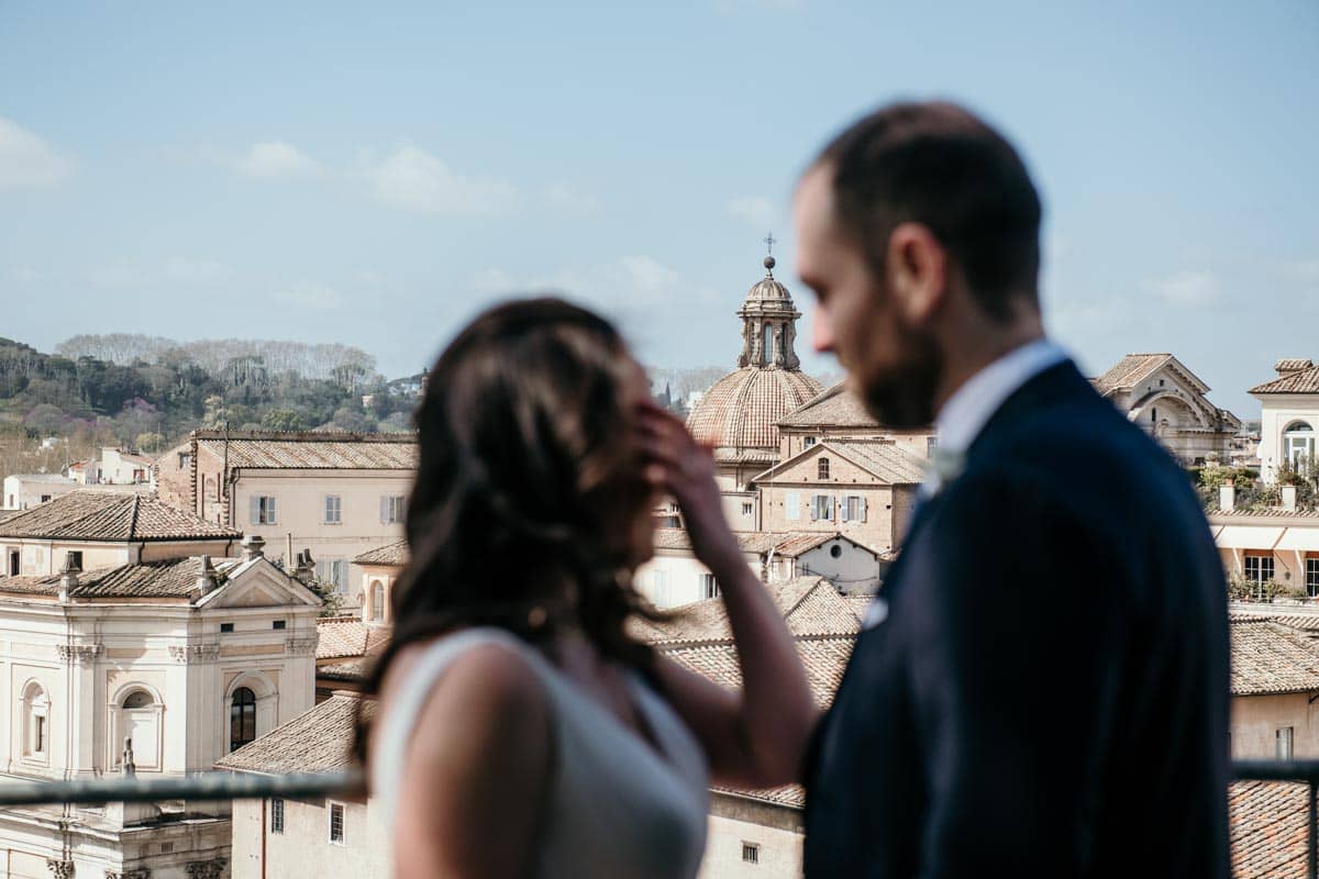 Coppia di sposi durante lo shooting del loro matrimonio a Roma, con lo sfondo della Sinagoga, in un'atmosfera romantica al Piazzale Caffarelli.