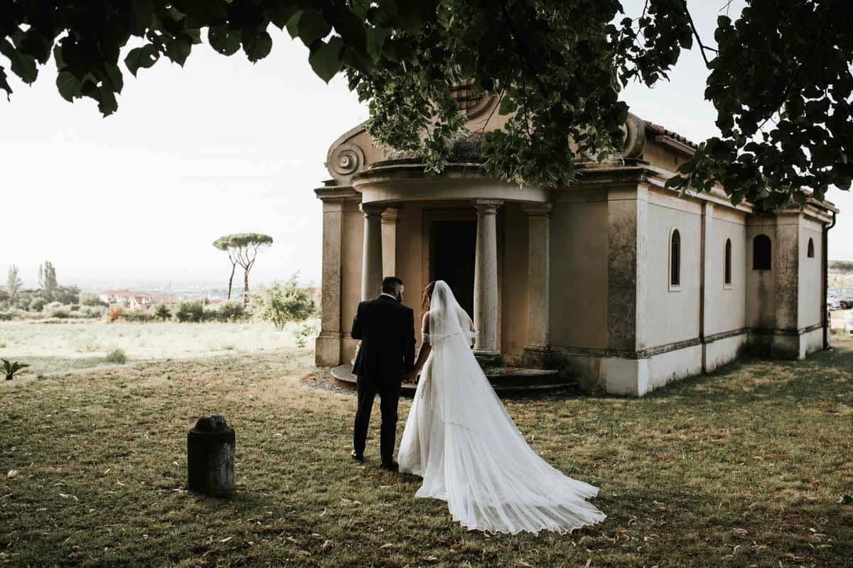 sposi-camminano-nella-luce-chiesa-romantica Gli sposi camminano verso l’altare, con la luce del pomeriggio che filtra nella chiesa — uno scatto intimo e naturale.