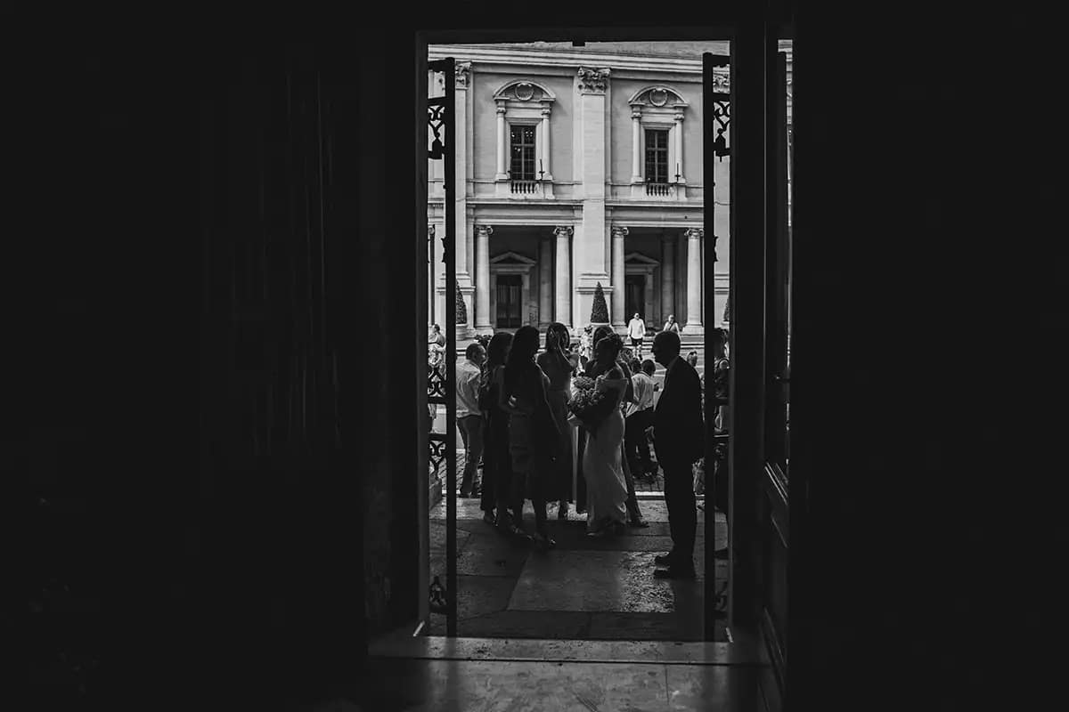 Fotografia di reportage degli ospiti in attesa dell'ingresso della sposa al Vignola, ingresso per la Sala Rossa del Campidoglio. Momenti spontanei e autentici.