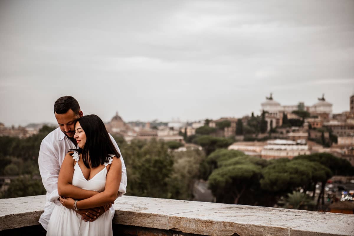 Una coppia si abbraccia al Giardino degli Aranci, con Roma sullo sfondo mozzafiato, durante un servizio fotografico prematrimoniale.