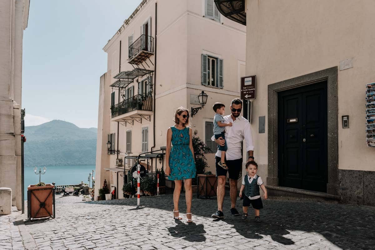 Famiglia con due bambini passeggia nel centro storico di Castel Gandolfo con vista lago