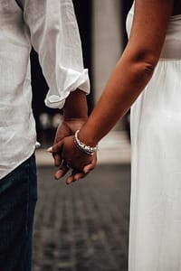 Coppia al Pantheon a Roma, dettagli delle mani che si intrecciano durante un servizio fotografico prematrimoniale, simbolo di connessione e amore.