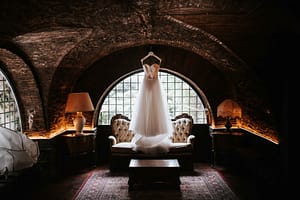 Vestito della sposa esposto nel salotto del Castello della Spizzichina a Roma, dettagli di pizzo e ambientazione raffinata