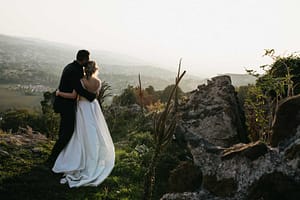 Coppia che si abbraccia mentre osserva il panorama mozzafiato dei Castelli Romani durante una sessione di elopement, in un paesaggio naturale e romantico.