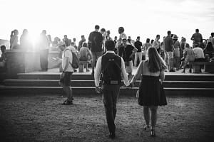 Francesco e Loise camminano mano nella mano al Giardino degli Aranci a Roma durante lo shooting fotografico per la proposta di matrimonio. Francesco porta uno zaino, simbolo di viaggio e ricordi condivisi.