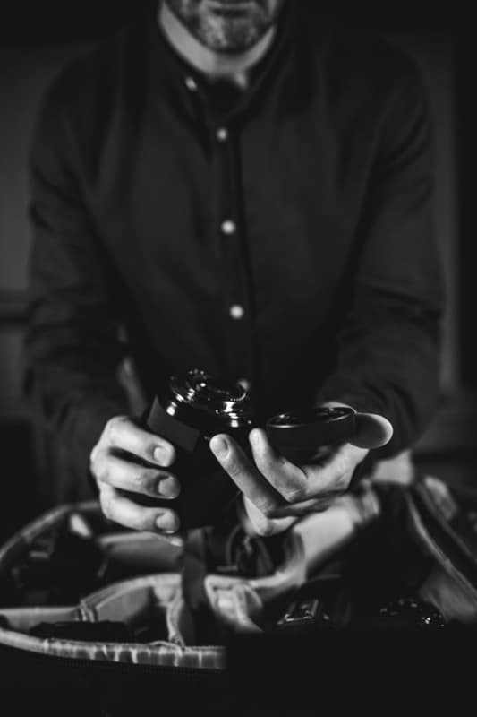 Controllo delle lenti fotografiche prima del servizio Le mani di Fabrizio Musolino mentre controlla gli obiettivi per un reportage di matrimonio a Roma