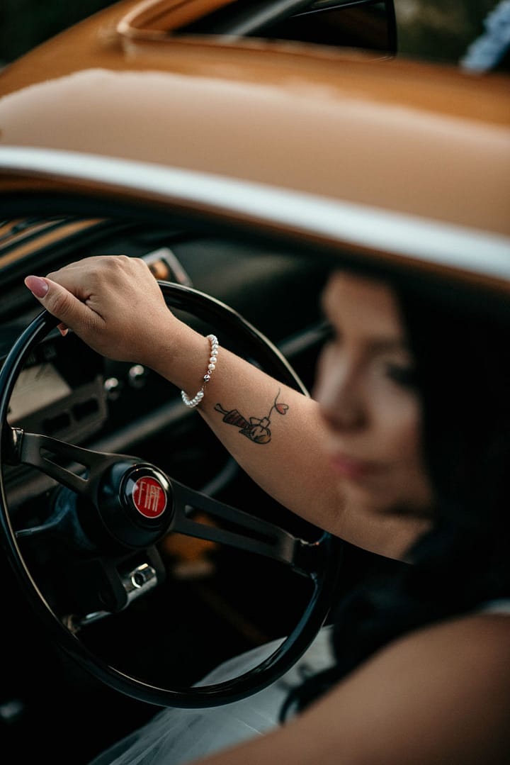 Dettaglio della sposa al volante di una Fiat 500 retrรฒ - Fotografo Matrimonio Roma
