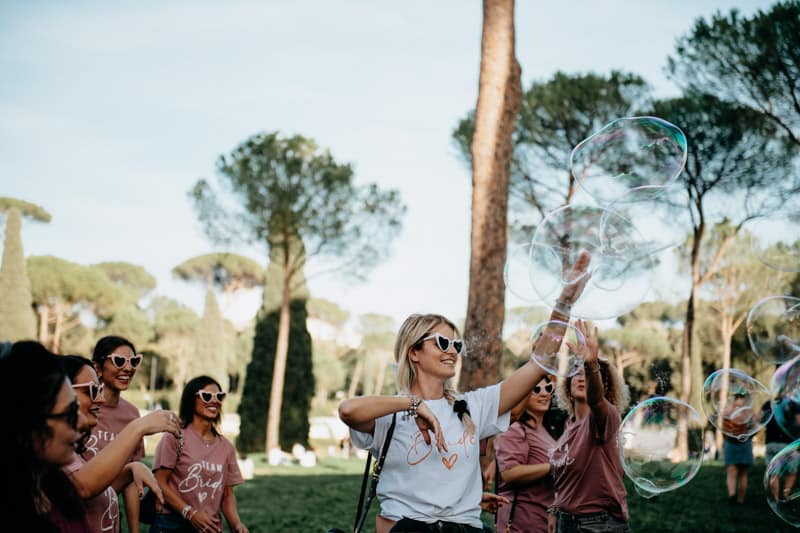 Momenti di gioco tra le amiche della sposa a Villa Borghese. Amiche che giocano insieme durante l'addio al nubilato a Villa Borghese.