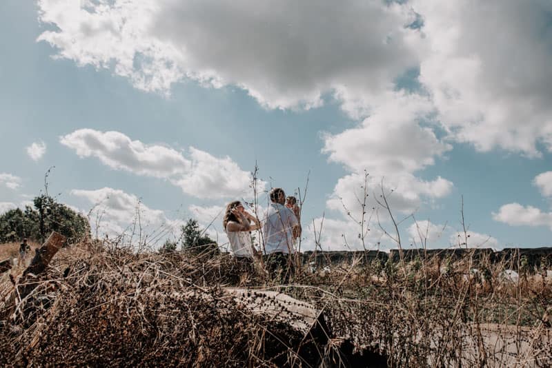 Momenti di Famiglia al Parco degli Acquedotti Papà che tiene in braccio la figlia mentre la mamma si rilassa, reportage al Parco degli Acquedotti